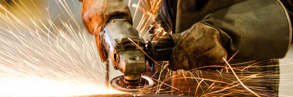 Industrial worker cutting steel tubes with an Angle Grinder. Source: Shutterstock, author: SasinTipchai